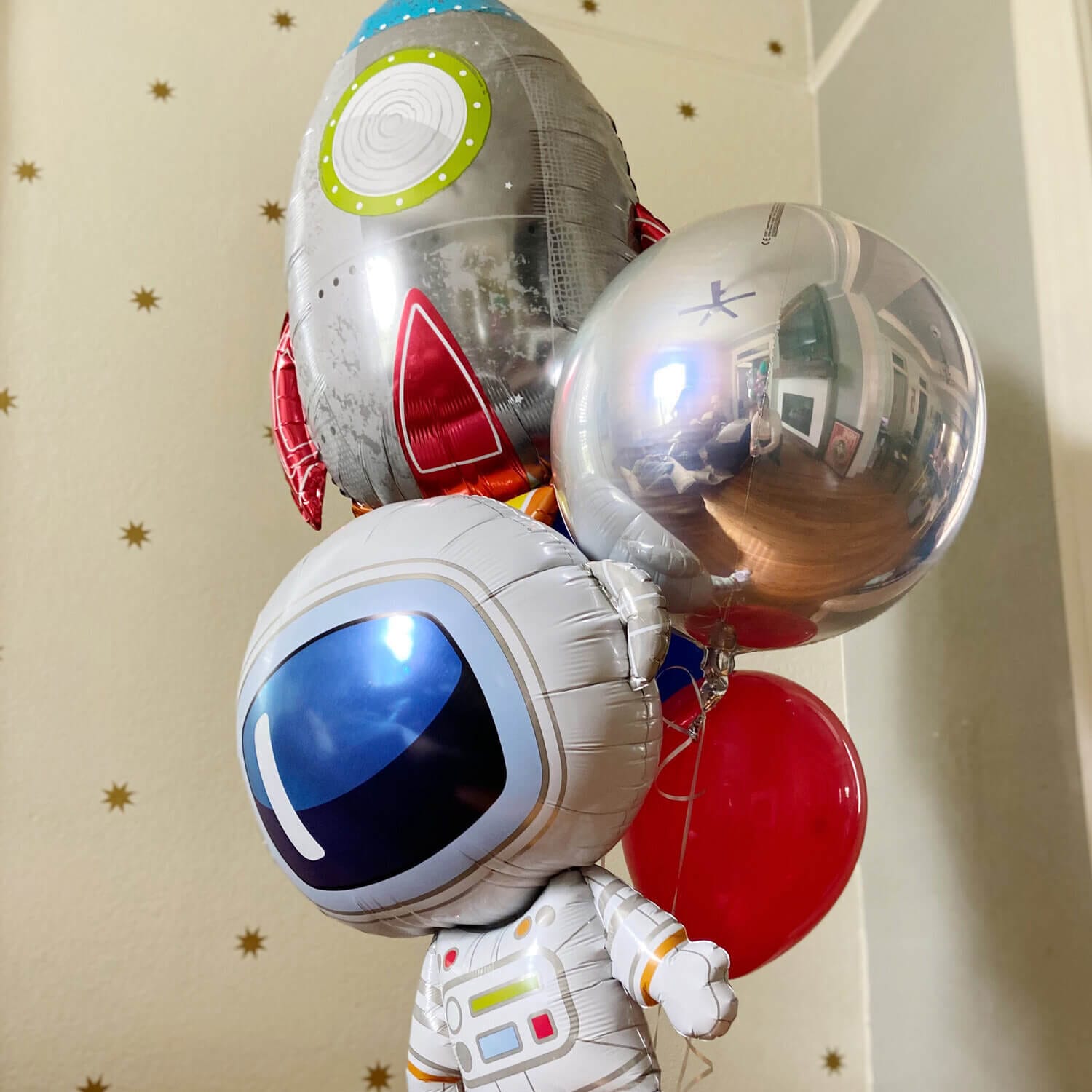 Just Peachy makes oversized helium bouquets like this one with astronaut, rocket ship, and silver orb balloons.