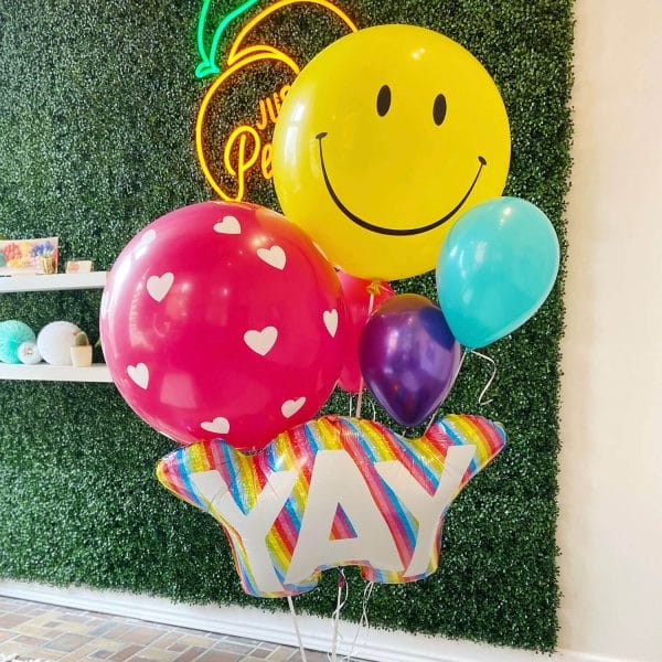Just Peachy makes giant helium bouquets, like this bundle of a giant smiley face, giant heart balloon, and YAY rainbow lettered balloon.