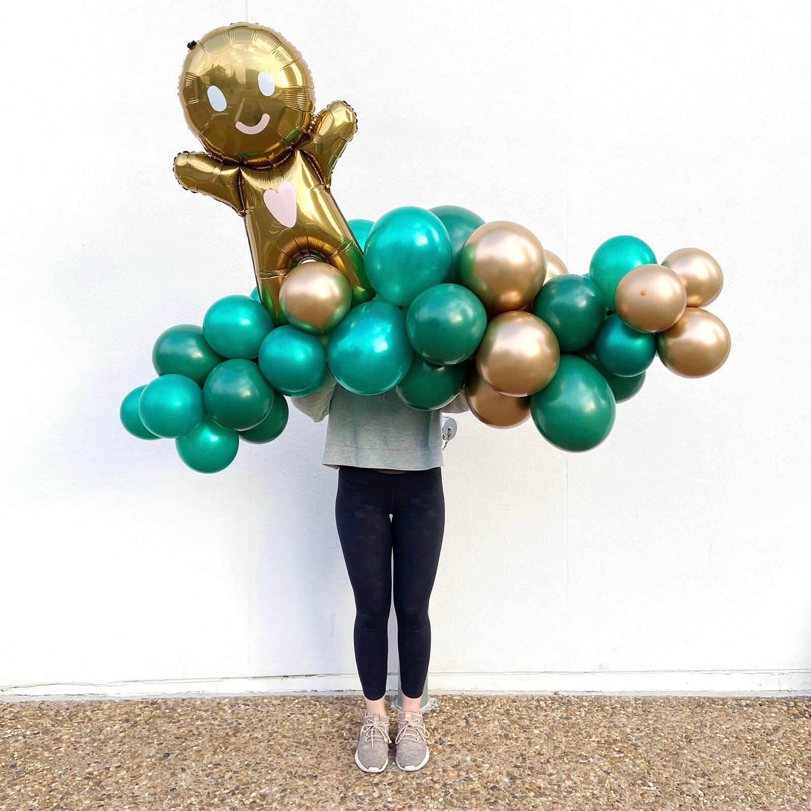 Evergreen holiday balloon garland with green and gold balloons, available from Just Peachy for Christmas.
