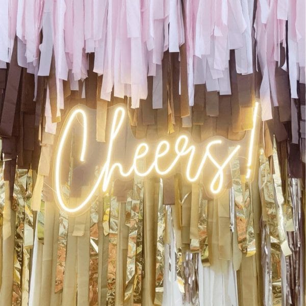 Warm white script lettering spells “Cheers” on this neon sign rental from Just Peachy.